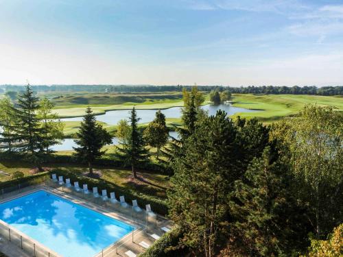 vista aerea su un campo da golf con piscina di Novotel Saint-Quentin en Yvelines a Magny-les-Hameaux