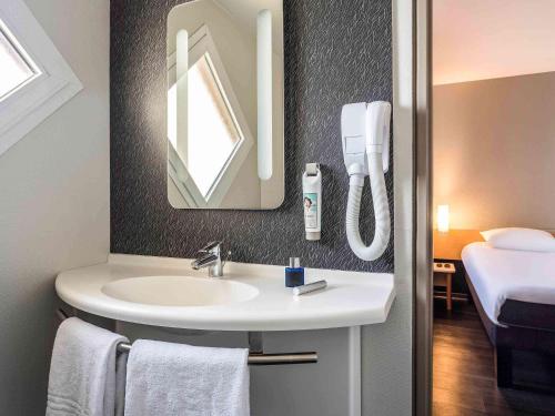 ein Bad mit einem Waschbecken und einem Spiegel in der Unterkunft ibis Thonon Centre in Thonon-les-Bains