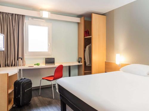 Habitación de hotel con cama y silla roja en ibis Thonon Centre, en Thonon-les-Bains