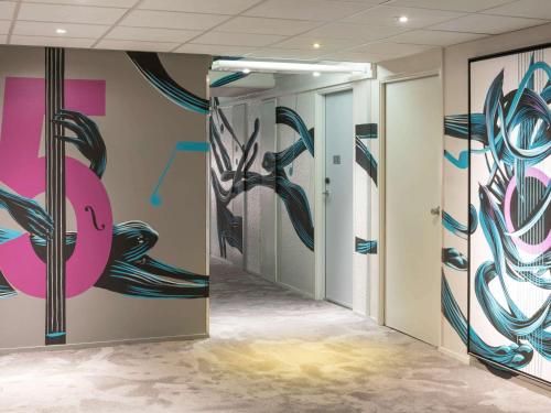 a hallway with a painting of a fish on the wall at ibis Styles Paris Bercy in Paris