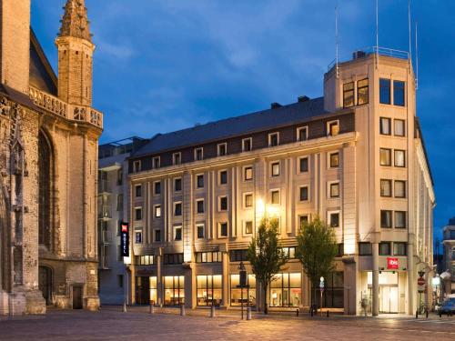 a large building with a clock on the front of it at ibis Gent Centrum St. Baafs Kathedraal in Ghent