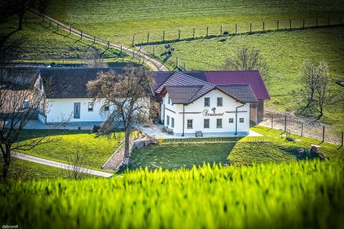 a white house with a purple roof in a field at Straußenhof Halmer in Oberndorf an der Melk