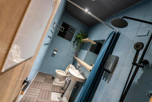 ein blaues Badezimmer mit WC und Waschbecken in der Unterkunft Ofucos Adventure Hostel in Gongliao
