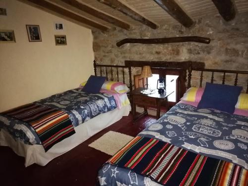 una camera con due letti e un tavolo in un edificio di El Sosiego a Morella