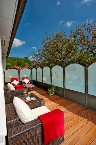 a balcony with wicker furniture on a deck at Romantikhotel Residenz Wachau in Aggsbach Dorf