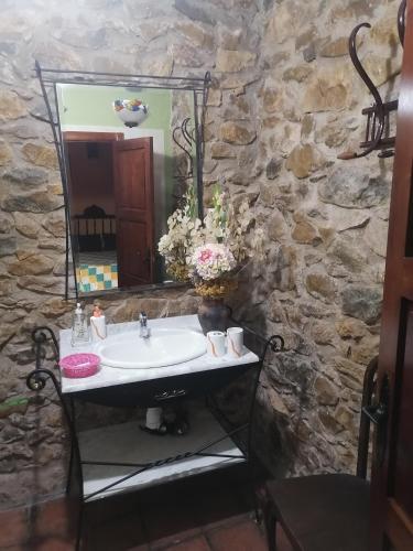 a stone bathroom with a sink and a mirror at El Sosiego in Morella