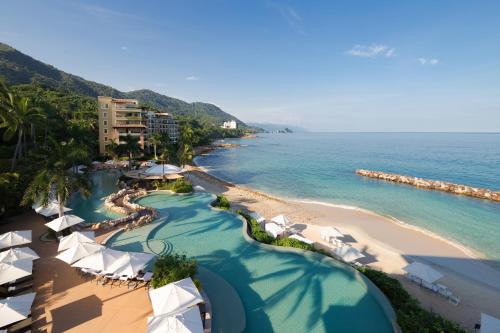 a view of a beach with white umbrellas and the ocean at Garza Blanca Preserve Resort & Spa in Puerto Vallarta
