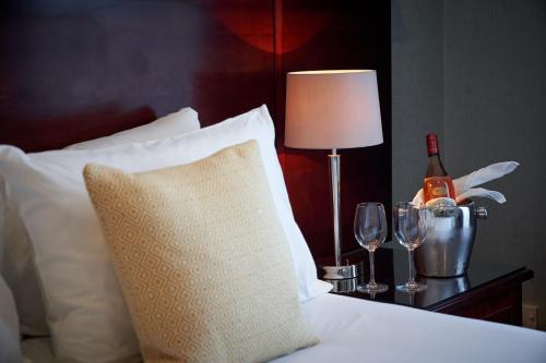 a bed with a bottle of wine and two glasses at Best Western Plus The Connaught Hotel and Spa in Bournemouth