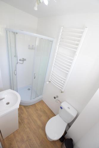 a white bathroom with a toilet and a sink at Johnny House in Suwałki