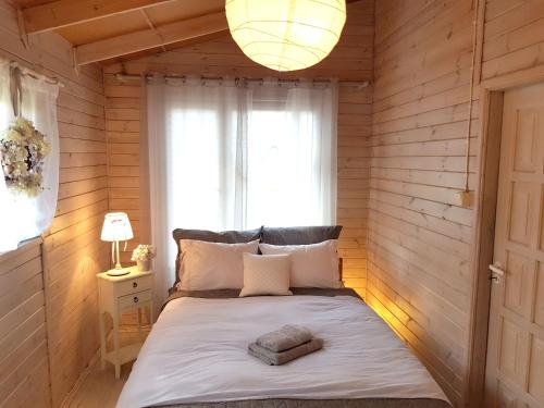 a bedroom with a large bed with a window at Mazurska Sielanka na Wiartlu in Pisz