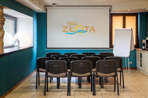a conference room with chairs and a projection screen at Hotel Willa Złota in Karwia