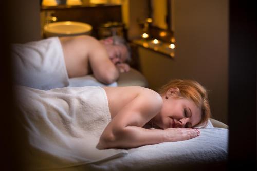 a woman laying on a bed with her head on a towel at Hotel Willa Złota in Karwia
