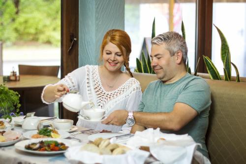 a man and woman sitting at a table eating food at Hotel Willa Złota in Karwia