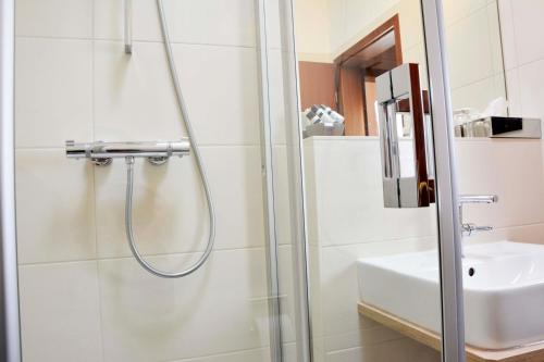 a bathroom with a shower and a sink at Hotel Restaurant "Zur Post" in Holdorf