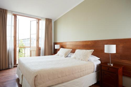 um quarto com uma cama grande e uma janela grande em Hotel Loreto em Santiago