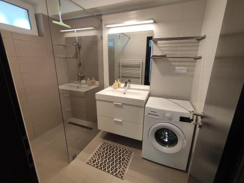 een badkamer met een wasmachine en een wasmachine bij Hatvan Corner Apartments 2 in Debrecen
