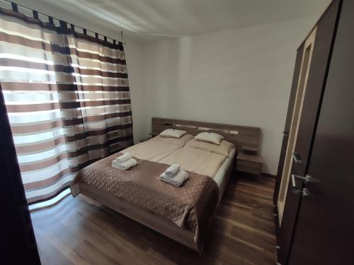 sypialnia z łóżkiem i dwoma ręcznikami na nim w obiekcie Hatvan Corner Apartments 2 w Debreczynie