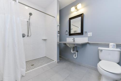 a bathroom with a shower and a toilet and a sink at Temple Place Suites in Boston