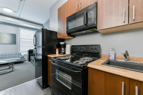 a kitchen with a black stove and a microwave at Temple Place Suites in Boston