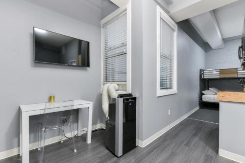 a living room with a bed and a desk and a television at Temple Place Suites in Boston