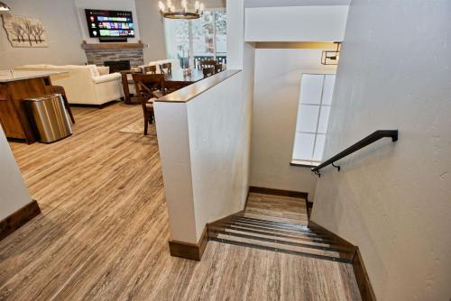 a staircase in a room with a living room and a kitchen at Silverpine Hideaway by Casago McCall - Donerightmanagement in McCall