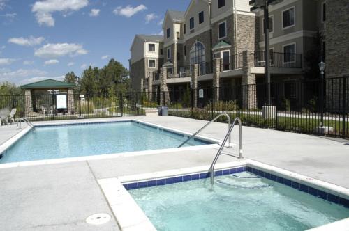 a swimming pool in a apartment complex with a building at Staybridge Suites Colorado Springs North by IHG in Colorado Springs