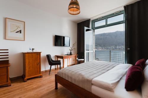 a bedroom with a bed and a large window at Hotel Esplanade in Gmunden