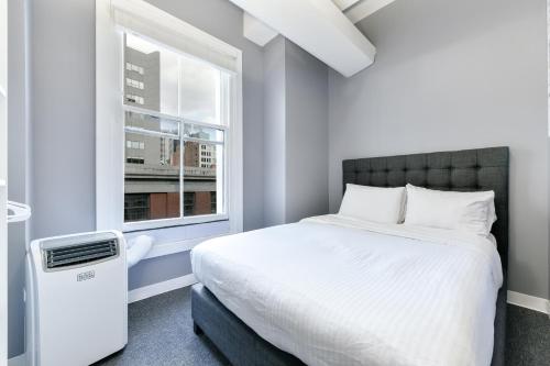 a bedroom with a white bed and a window at Temple Place Suites in Boston