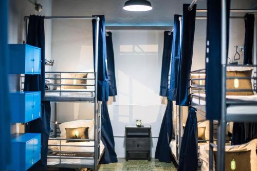 a room with four bunk beds in it at Nomada Urban Beach Hostel- Calle Loiza in San Juan