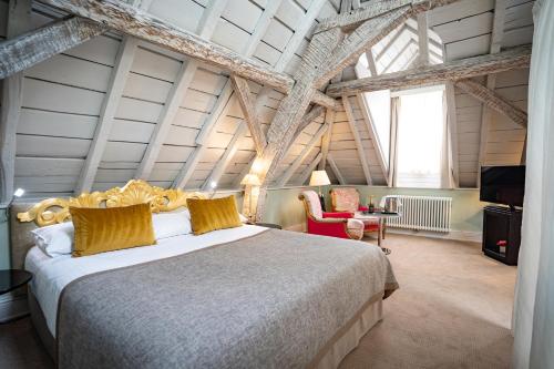una camera con un grande letto in una stanza con travi di Hotel Le Place d'Armes - Relais & Châteaux a Lussemburgo