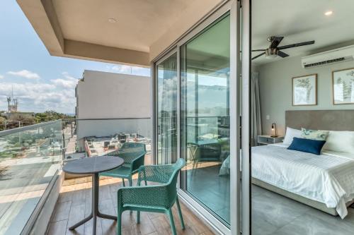 a bedroom with a bed and a table and chairs on a balcony at Turchese 303 N @ The Gallery in Playa del Carmen