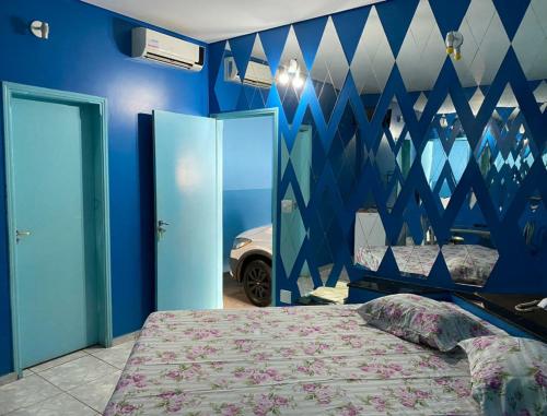 a bedroom with a bed and a blue wall at Aquarius Motel IV in Araraquara