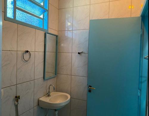 a bathroom with a sink and a window at Aquarius Motel IV in Araraquara