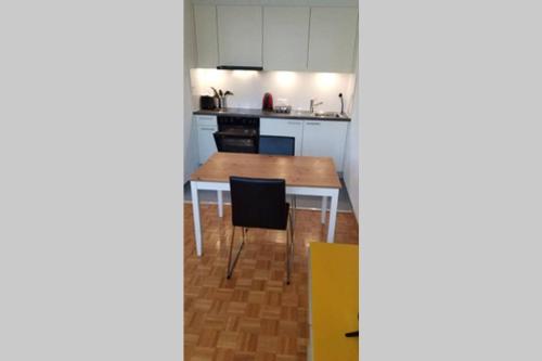 cocina con mesa y sillas en una habitación en HSH Barre 6 - City Apartment next Cathedral Lausanne, en Lausana