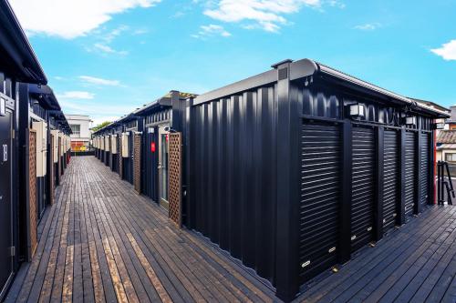 a row of black shipping containers on a street at HOTEL R9 The Yard Sanotenjin in Sano