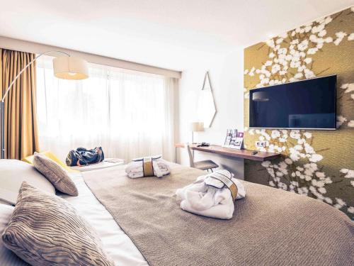 una camera d'albergo con due letti e asciugamani di Mercure Bourg En Bresse a Bourg-en-Bresse