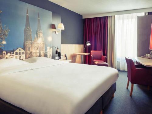 a hotel room with a large bed and a large window at Mercure Hotel Tilburg Centrum in Tilburg