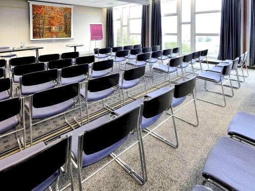 a conference room with chairs and a long table at Mercure Rouen Val de Reuil in Val de Reuil