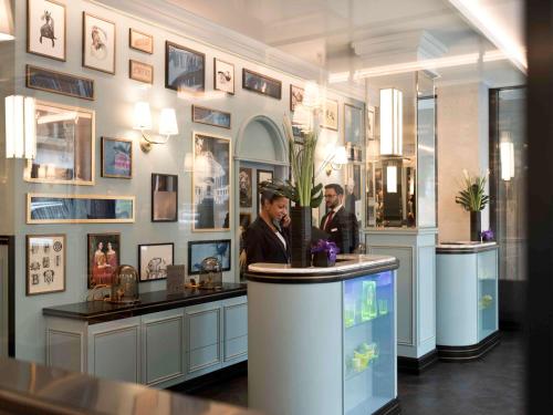 deux hommes debout à un comptoir dans un salon de coiffure dans l'établissement Hotel Rotary Geneva - MGallery, à Genève