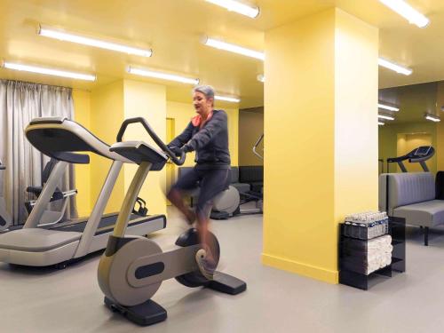 a man running on a treadmill in a gym at Mercure Rouen Centre Cathédrale in Rouen