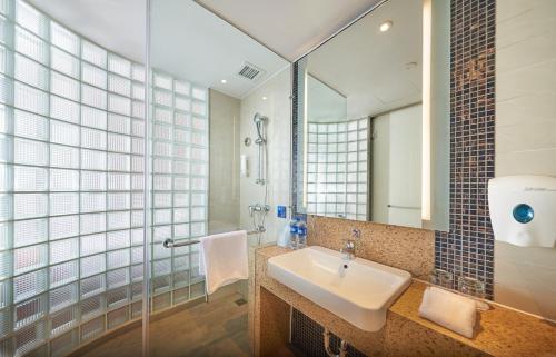 uma casa de banho com um lavatório e um espelho em Holiday Inn Express Shanghai Jiading Industry Park, an IHG Hotel em Jiading