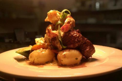 a plate of food with meat and potatoes on it at Shellharbour Resort and Conference Centre in Shellharbour