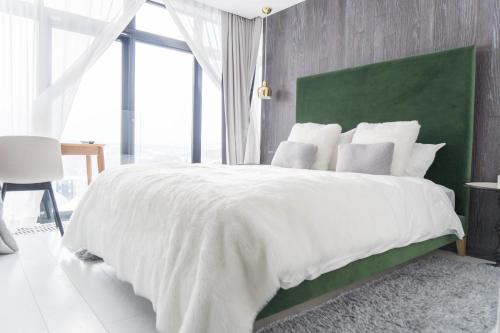 een slaapkamer met een groot wit bed met een groen hoofdeinde bij Loft Niseko in Niseko