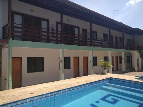 a building with a swimming pool in front of a building at Chalés Marazul Toninhas in Ubatuba