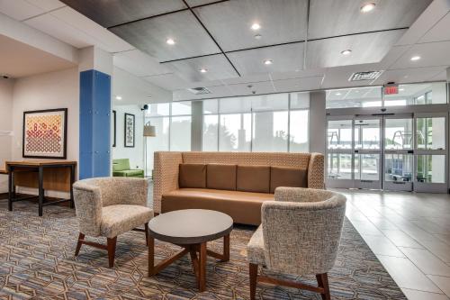 a lobby with a couch and two chairs and a table at Holiday Inn Express & Suites Dallas North - Addison by IHG in Addison