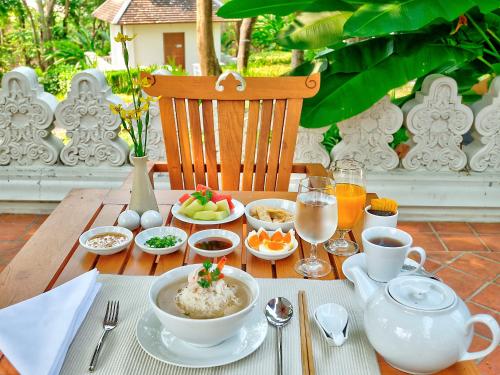 a table with bowls of food and drinks on it at MonPanaNont Wellness Resort & Spa in Mae Taeng