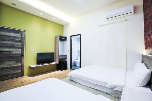 1 dormitorio con 2 camas y TV de pantalla plana en Amethyst Bay Theme HomeStay II, en Magong