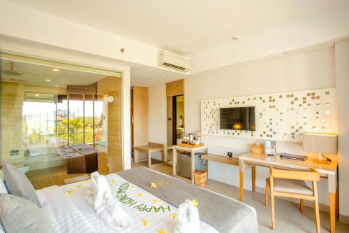 a bedroom with a bed and a desk and a room at Jimbaran Bay Beach Resort and Spa by Prabhu in Jimbaran