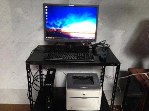 a computer monitor and keyboard and a printer on a desk at Narita Airport Samurai Hostel in Kujukuri