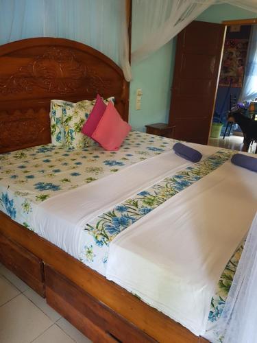 a bedroom with a large wooden bed with two pillows at Familyhouse in Negombo